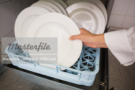 Chef putting plates in drying rack
