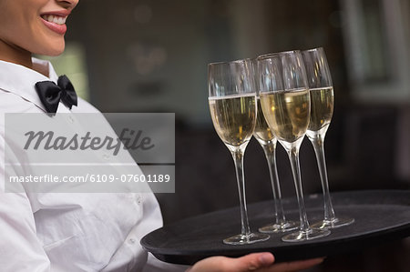 Pretty waitress holding a tray of champagne Pretty waitress holding a tray of champagne