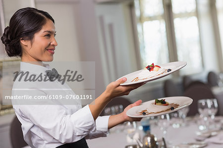 Pretty waitress holding two dessert plates