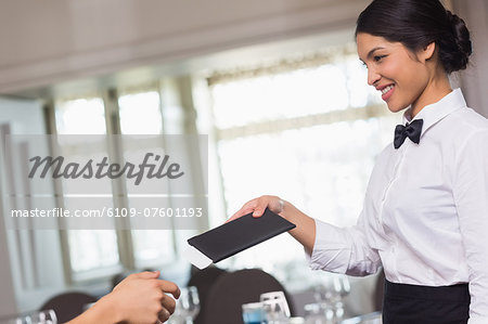 Happy waitress holding the bill