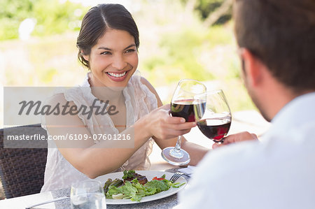 Happy couple toasting with red wine on a date