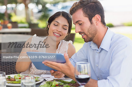 Happy couple on a date using tablet pc