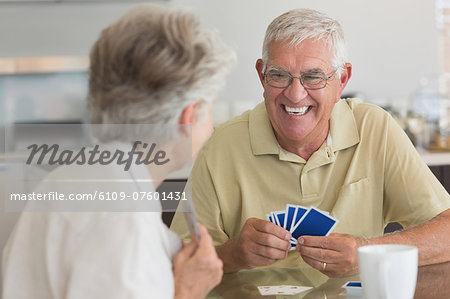 Happy senior couple playing a card game