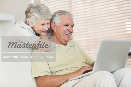 Happy senior couple using the laptop together
