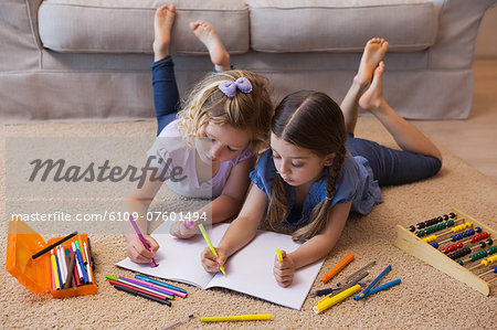Siblings drawing in the living room