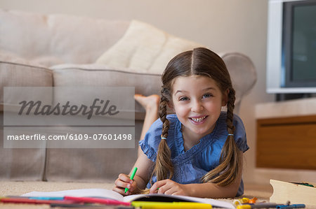 Portrait of a little girl drawing in living room
