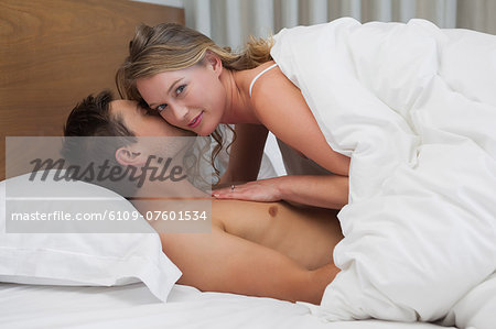 Side view of a loving relaxed couple in bed