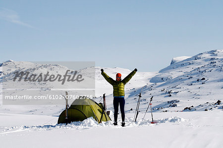 Woman near tent in winter mountains, Riksgransen, Lapland, Sweden
