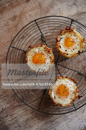Eggs in baked hash brown nest with goat cheese and arugula filling