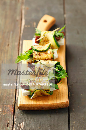 Grilled rolled slices of courgette filled with rocket, feta and sundried tomatoes Grilled rolled slices of courgette filled with rocket, feta and sundried tomatoes