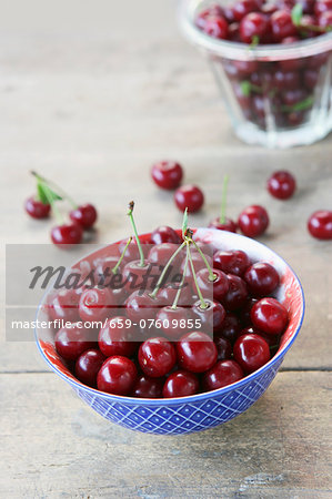 Fresh cherries in a blue and white bowl on a wooden surface
