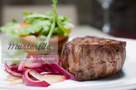 sirloin steak with red onions, tomatoes and rocket leaves