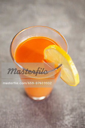 a cocktail made out of fresh vegetable and fruit - juice / carrots, orange, beetroot, lemon