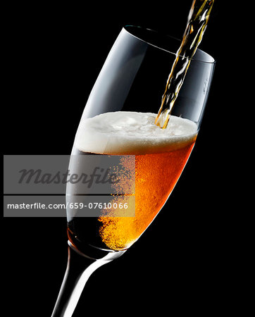 Cold Beer Pouring From a Bottle into a Glass; Overflowing