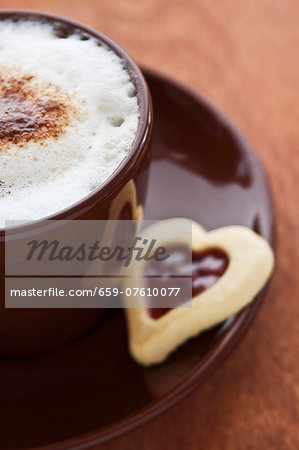 A cappuccino and a jam biscuit A cappuccino and a jam biscuit