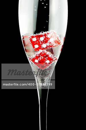 detail of a flute with two red dice and a lot of bubbles on black background