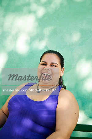 Portrait of overweight hispanic woman looking at camera and smiling