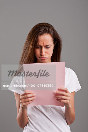 girl pouts because she read something bad on a pink document maybe by a lover or a money loss