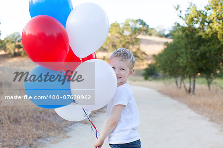 little cheerful boy holding colorful balloons and celebrating 4th of July