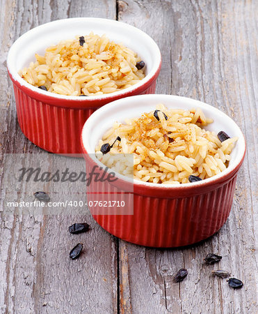 Delicious Steamed Rice with Spices and Barberry in Red Bowls isolated on Rustic Wooden background