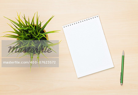 Blank notepad, pen and flower on wooden table. View from above