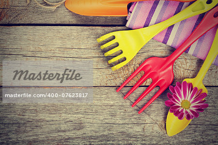 Garden tools with flower on wooden table background with copy space. Retro style