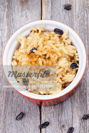 Steamed Rice with Spices and Barberry in Red Bowl on Rustic Wooden background. Top View