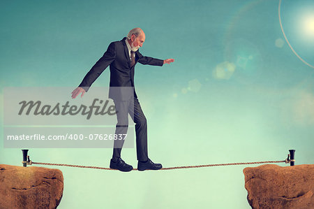 senior man walking on a tightrope or highwire