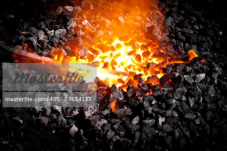 Conceptual image of a hot iron in burning coals