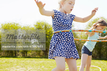 Low angle view of two girls playing with plastic hoops