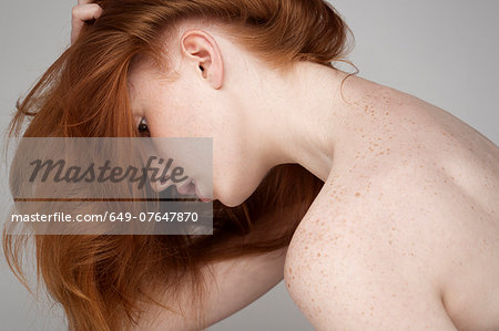 Portrait of young woman, leaning forwards with hair forwards