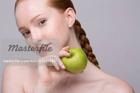 Portrait of young woman, holding green apple Portrait of young woman, holding green apple