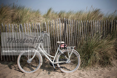 Traditional bicycle against sand dune fence, Vollendam, Netherlands