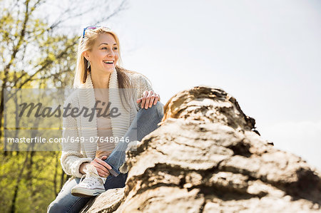 Smiling young woman sitting in forest