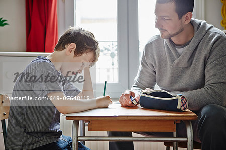 Father helping son with homework Father helping son with homework