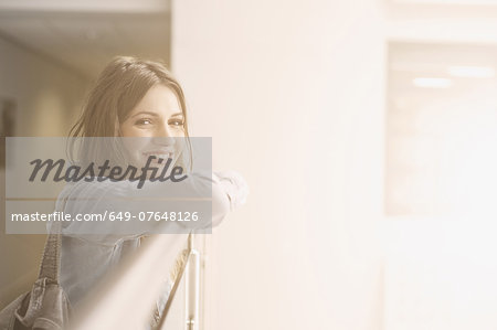 Young woman leaning on railing, portrait