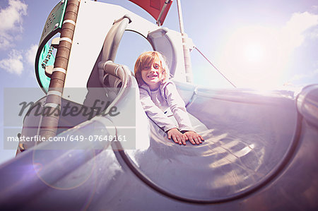 Boy coming down slide on front