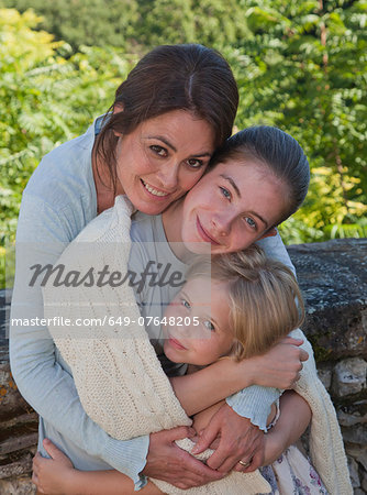 Mother and daughters in garden, hugging