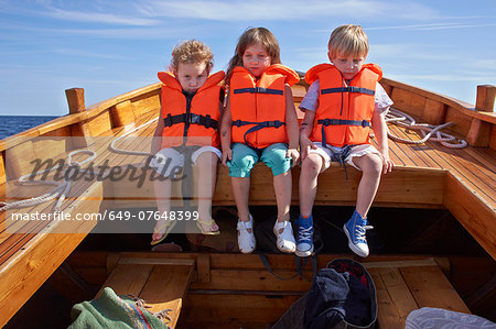 Three children sitting in boat