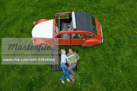 Overhead view of mature couple relaxing on picnic blanket