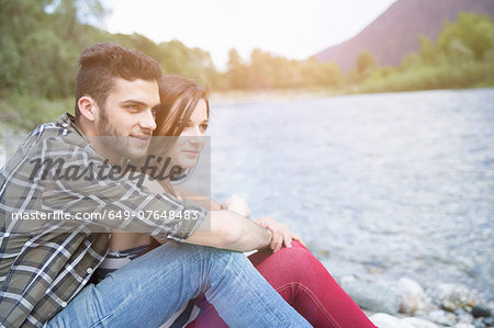 Young couple gazing on Toce riverbank, Piemonte, Italy