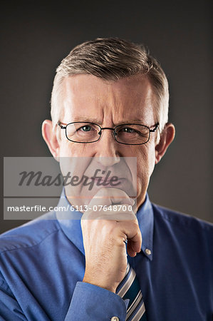 Portrait of confident businessman with hand on chin