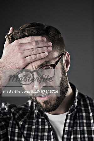 Worried man with head in hands
