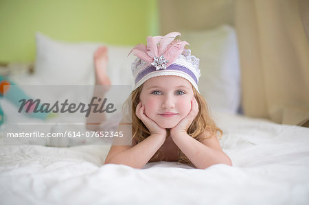 Portrait of young girl in princess headdress on bed Portrait of young girl in princess headdress on bed