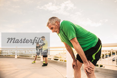 Exhausted male runners taking a break from training