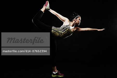 Young woman standing on one leg