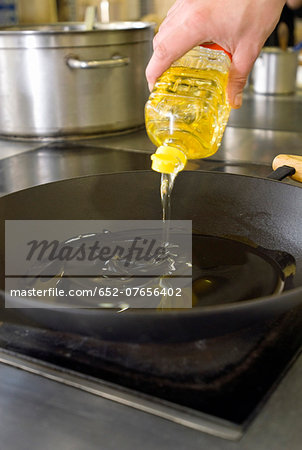 Pouring oil into a frying pan