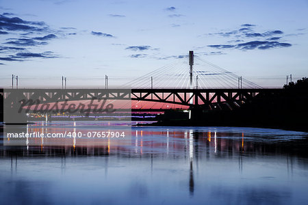 Bridge at night and reflected in the water. Swietokrzystki bridge.