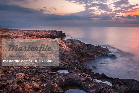 Rocky Beach and Colourful Sky on Cloudy Morning