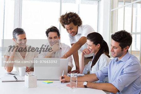 Attractive business people laughing and discussing at a business meeting